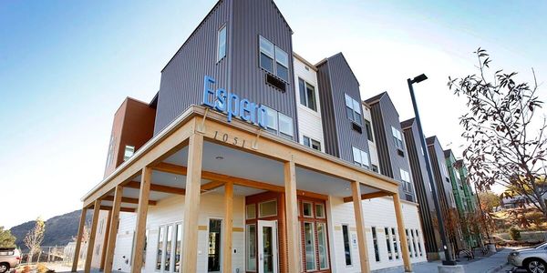 Exterior image of Espero, an apartment complex made of grey sheet metal siding and wood structures.