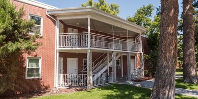 An exterior image of the COADs, an apartment complex made of brick, with a white exterior stairwell.