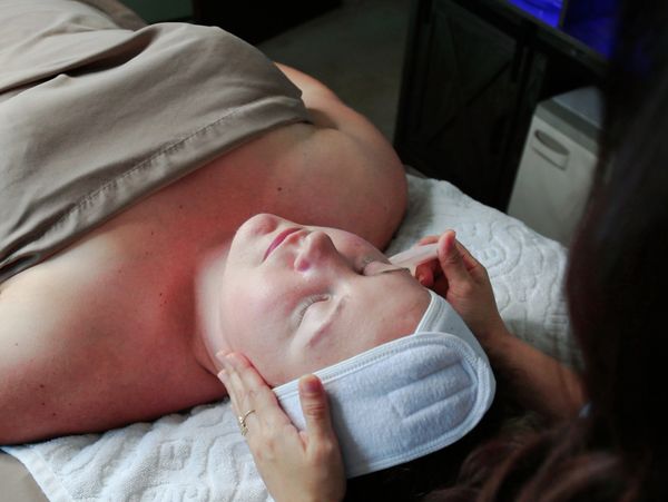 a woman getting facial done by a professional 