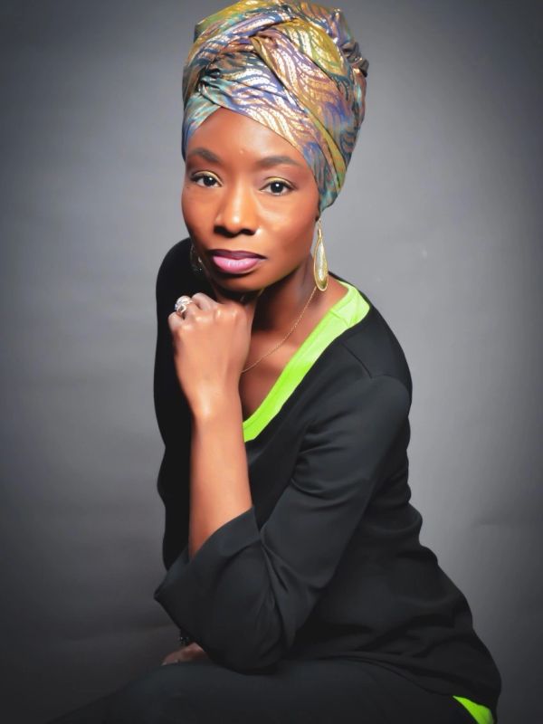 Confident woman with a colorful headwrap and elegant pose.