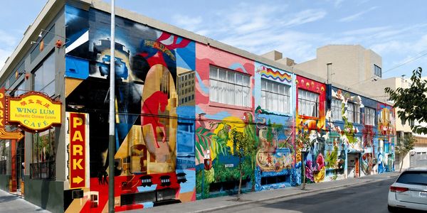 Colorful mural covering a building wall in an urban area.