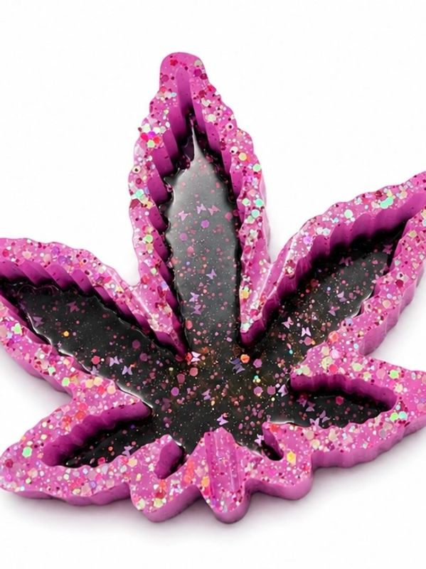 Colorful resin art shaped like a leaf with glitter accents.