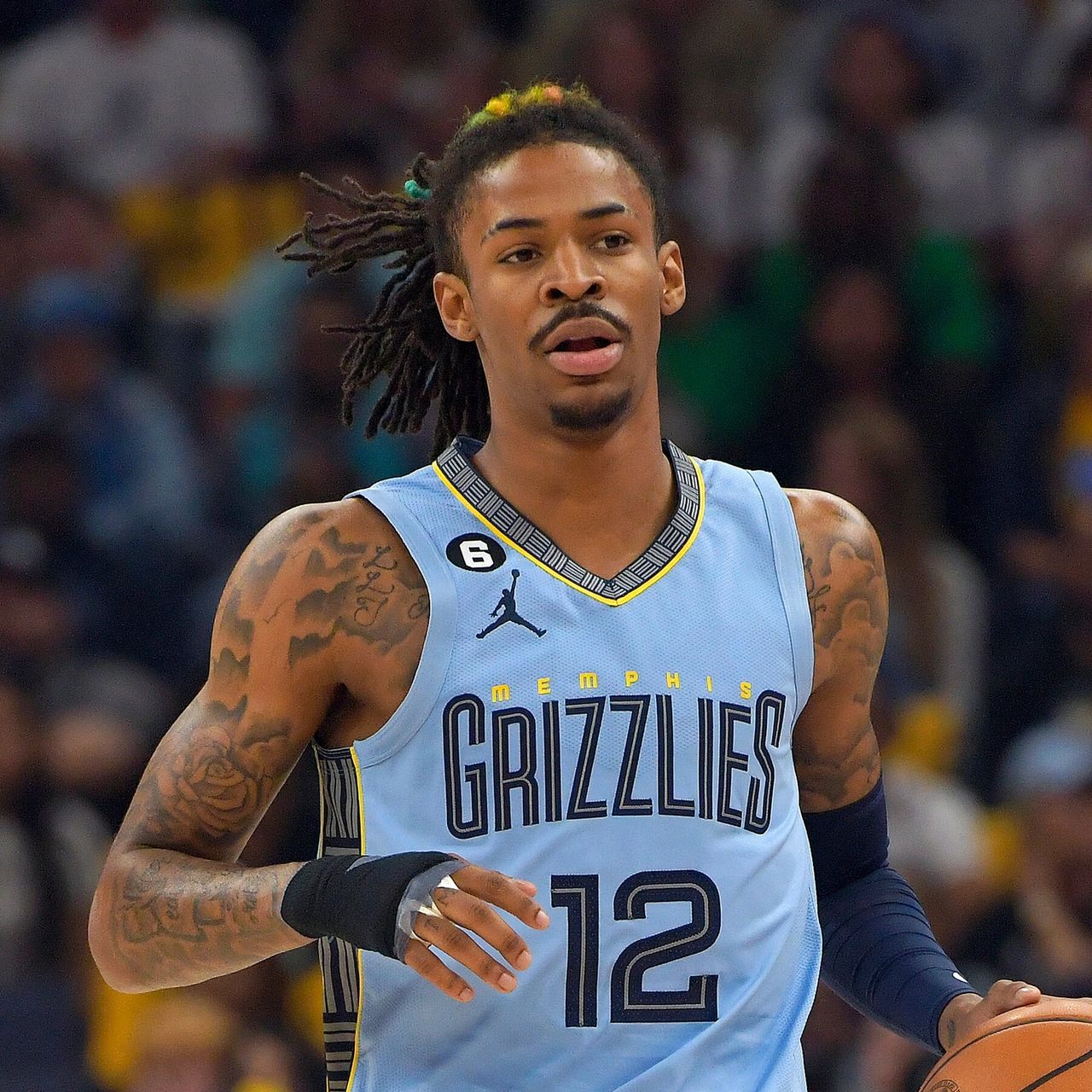 Ja Morant, wearing a Memphis Grizzlies jersey, prepares to make a play on the basketball court.