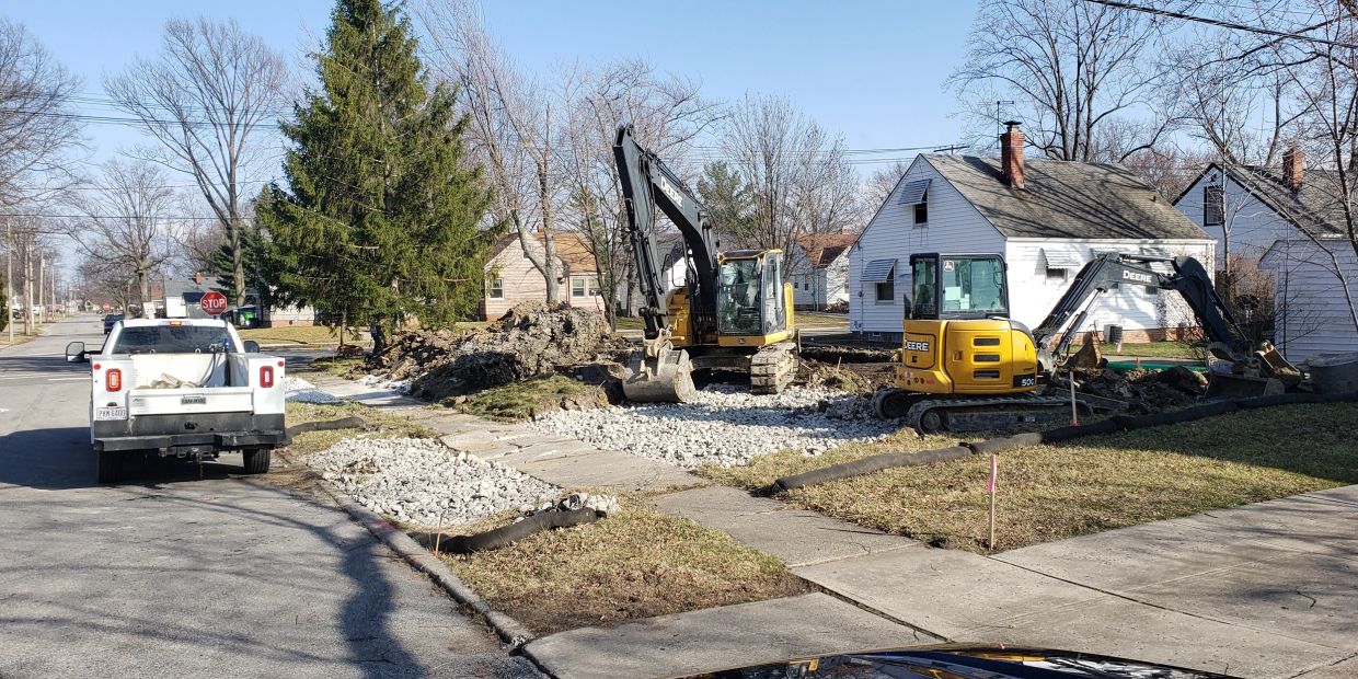 Construction site with excavators and a white pickup truck.