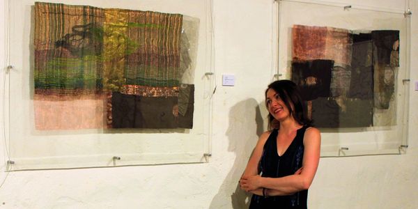 Woman admiring abstract art pieces in a gallery.