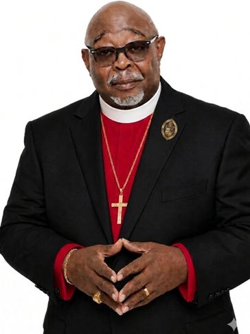 A man in clerical attire with a cross necklace and glasses.