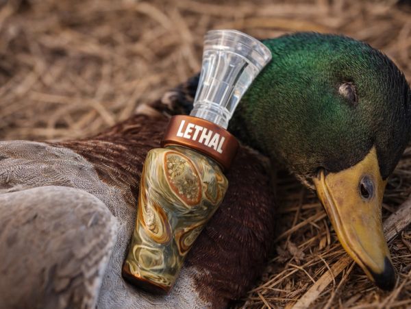 A duck call labeled 'LETHAL' rests on a sleeping duck.