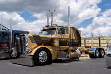 Classic Peterbilt truck parked outdoors under a partly cloudy sky.