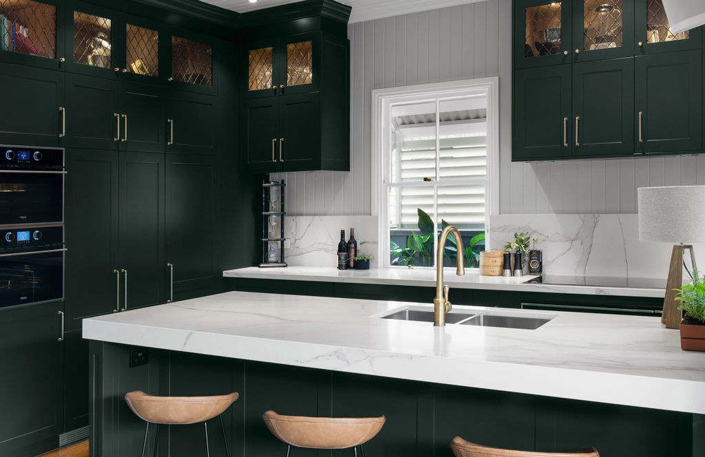 Queenslander kitchen with dark cabinets and light-veined stone benchtop