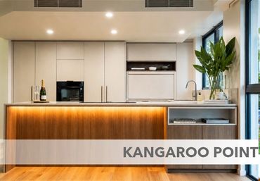 Modern kitchen with wooden and white cabinetry and under-counter lighting.