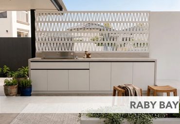 Modern outdoor kitchen setup with clean lines and wooden stools.