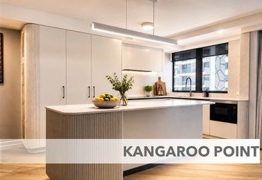 Modern kitchen with island, large windows, and clean design.