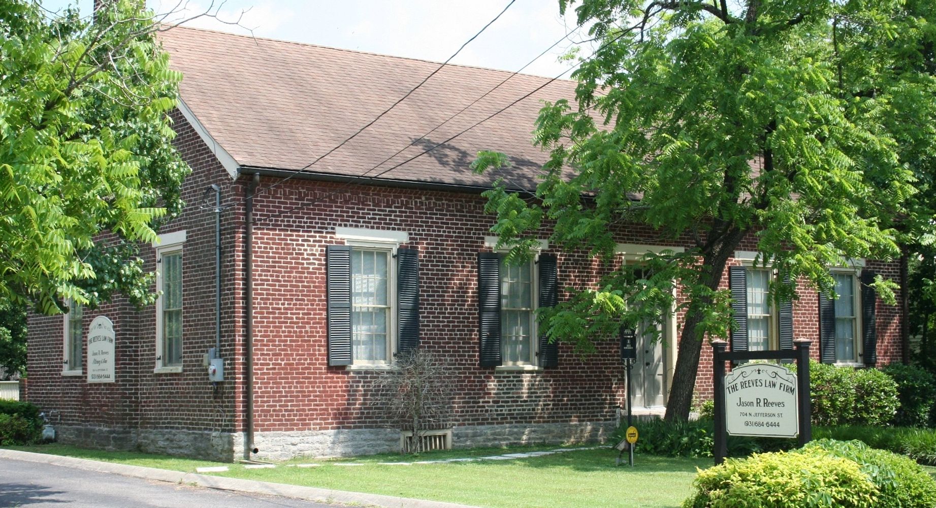 Stack of books next to pencils in a holder and a camera.