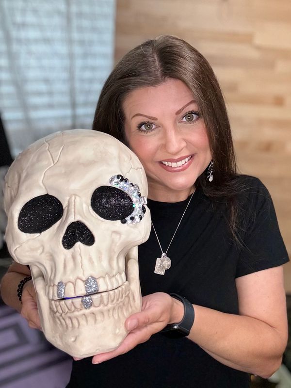 Photo of designer holding DIY jeweled Halloween skull.