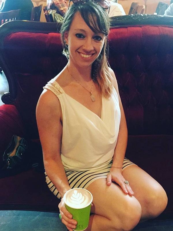 woman sitting on couch holding a cup of coffee