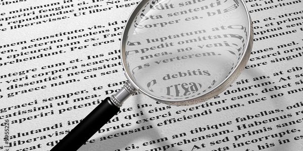 Magnifying glass enlarging text on a printed page.