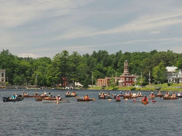 A group of people rowing boats on a lake.