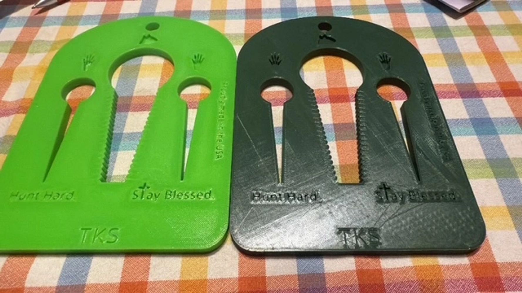 Two plastic hand strength trainers labeled 'Hunt Hard' and 'Stay Blessed'.