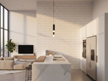 Modern kitchen with marble island and large windows.