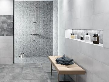 Modern bathroom with tiled shower and bench.