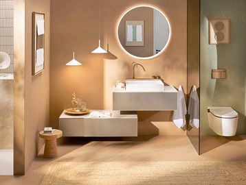 Modern bathroom with warm tones and circular mirror.