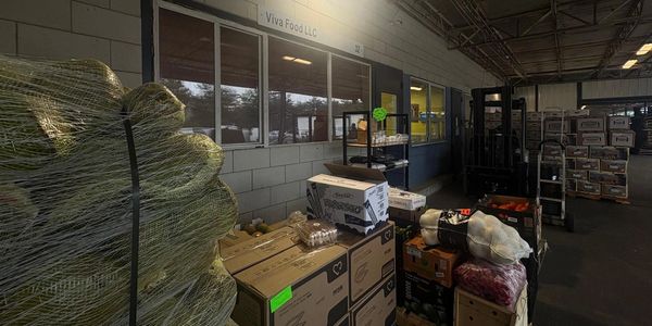 Warehouse area with stacked boxes and wrapped goods.