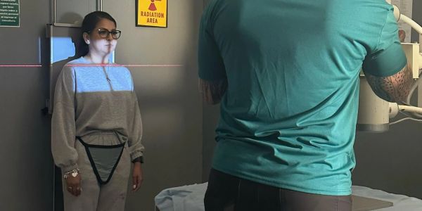 Woman undergoing a dental x-ray with protective apron.