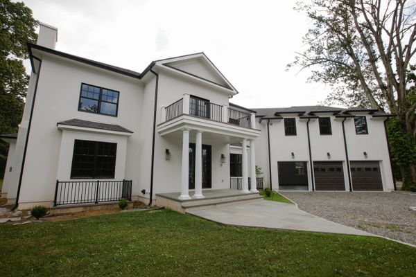 Modern white house with black-framed windows and a three-car garage.