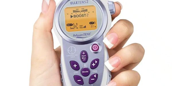 Hand holding an ELLETENS2 Babycare TENS device with control buttons and display.