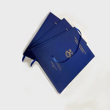 Three blue hardcover books with gold lettering and a ribbon bookmark.
