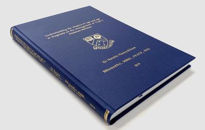 Blue hardcover thesis book with gold text and emblem on the cover.