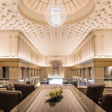 Elegant dining area with chandelier and ornate ceiling.