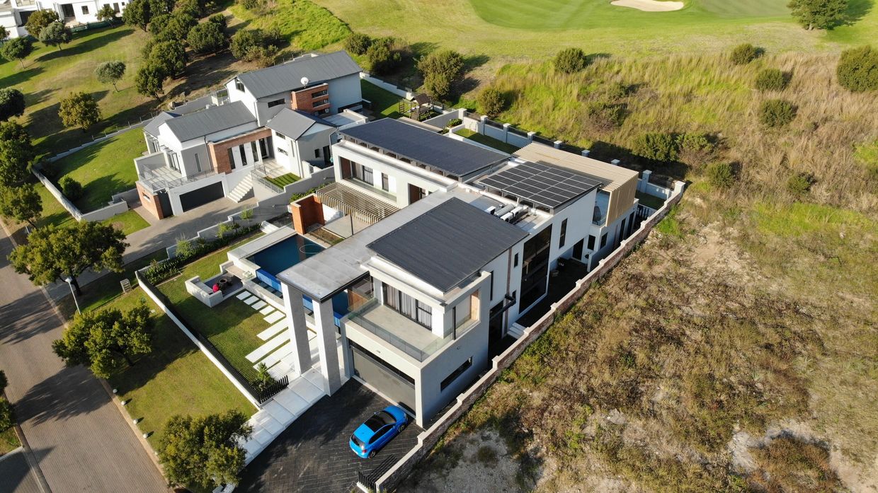 Modern luxury house with solar panels and a private pool in a green neighborhood.