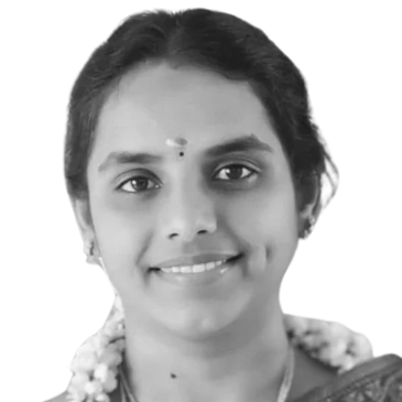 A woman in a traditional saree with floral embroidery and gold jewelry.