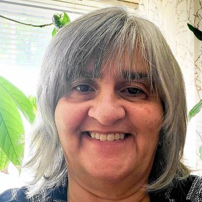 Smiling woman with gray hair in a bright room.