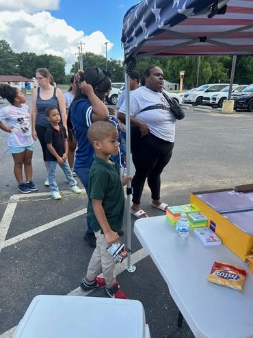 Children receiving backpacks filled with school supplies