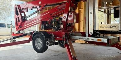 A red Europelift machine parked inside a garage with stabilizing legs extended.
