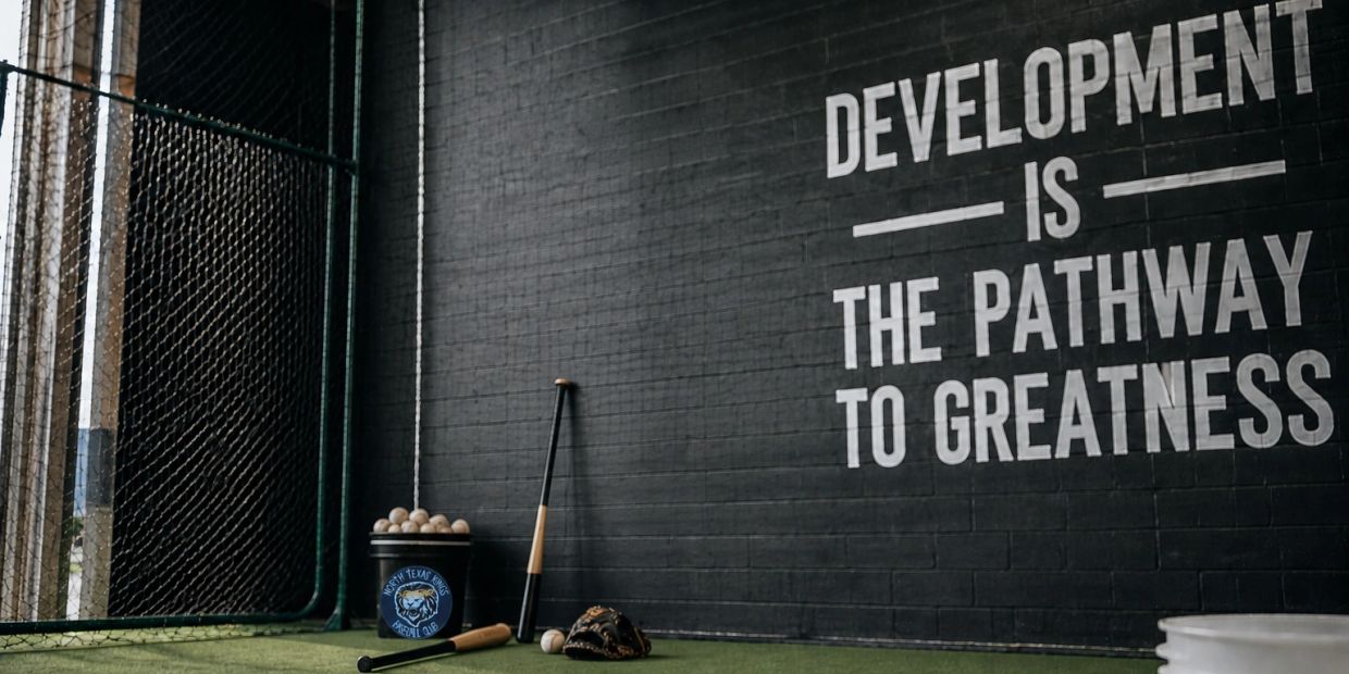 Baseball practice area with motivational quote on wall.