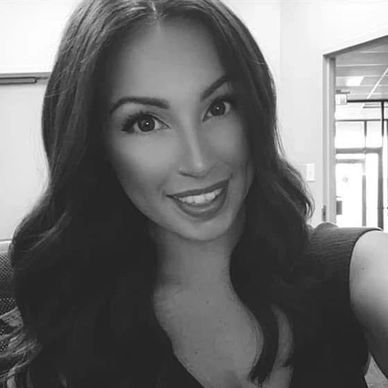 Smiling woman with long hair in black and white photo.