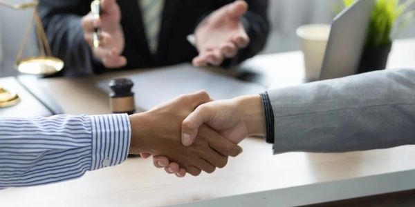 Two people shaking hands in a business meeting.