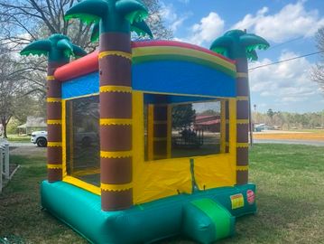 Colorful inflatable bounce house with palm tree design outdoors.