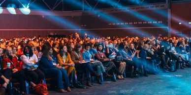 Audience attentively watching a presentation in a large conference.