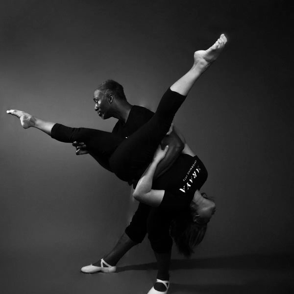 Two dancers performing an intricate, graceful pose in black and white.