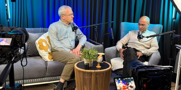 Two men recording a podcast in a cozy studio.