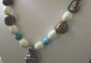 EE-136 Tibetan Magic: Conch Shell Bead with Turquoise and Repousse design, strung with Turquoise and vintage White Beads, accented with four Tibetan Melon-Shaped Chank Shell Beads and two Tibetan Repousse Beads. $85