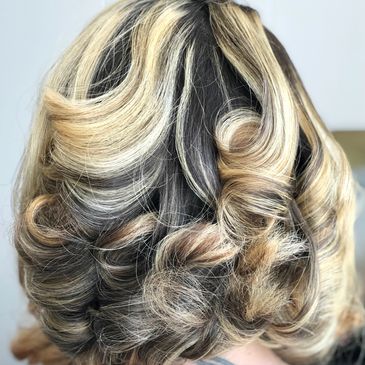 Blonde and brown hair styled in soft, voluminous curls.