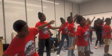 Kids dancing in a classroom rehearsing a routine.