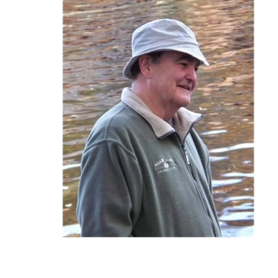 Man wearing a bucket hat by water.