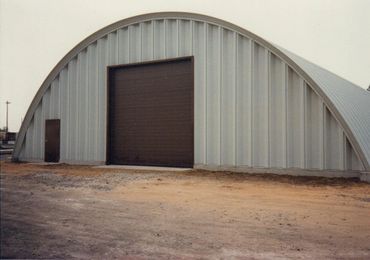 Curved metal building with dark bay door