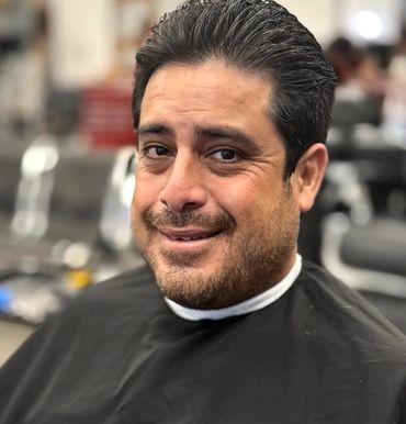 Man smiling in a barbershop.
